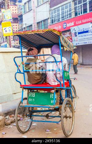 DELHI, INDIEN - 10. NOVEMBER: Rikscha-Fahrer wartet am frühen Morgen des 10,2012. November in Delhi, Indien, auf Passagiere. In Delhi wurden Fahrradrickshaws eingeführt Stockfoto
