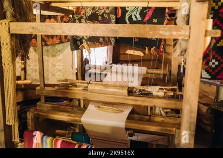 Ein Webstuhl in einem alten Holzhaus, das im 19.. Jahrhundert gebaut wurde Stockfoto
