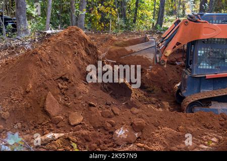 Es handelt sich um einen kleinen Traktor, der für den Bodenbeschaffungsbau auf der Baustelle verwendet wird. Stockfoto