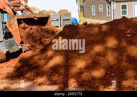 Dieser kleine Traktor wird bei der Bodenbewegung für die Landschaftsgestaltung auf der Baustelle eingesetzt Stockfoto