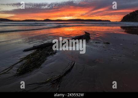 Eine Landschaftsaufnahme des Umina Beach unter dem dramatischen, lebhaften Sonnenaufgang - ideal für Tapeten Stockfoto