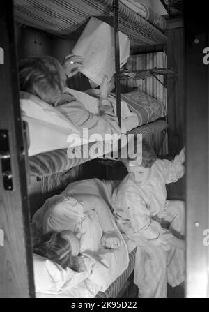 Schlafwagen der Klasse AB02C, 3.. Der Mann lügt und liest die Zeitung. Stockfoto