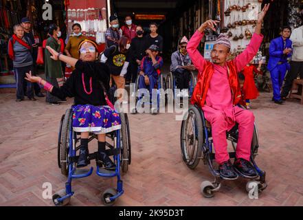 Kathmandu, Nepal. 26. Oktober 2022. Menschen mit Behinderungen und Beeinträchtigungen tanzen und singen zum Lied von Deusi Bhailo, das während des Tihar-Festivals, bekannt als Diwali, dem Lichterfest in Boudhanath Stupa, einem UNESCO-Weltkulturerbe in Kathmandu, für Glück, Freude und Glück unter den Menschen gesungen wird. Ein Team von dreizehn Menschen mit unterschiedlichen Behinderungen initiierte die 3-tägige musikalische Veranstaltung von Deusi Bhailo für das soziale Bewusstsein und die Bedeutung des großen Hindu-Festivals in der Gesellschaft mit Wünschen an alle Nepalesen auf der ganzen Welt. Kredit: SOPA Images Limited/Alamy Live Nachrichten Stockfoto