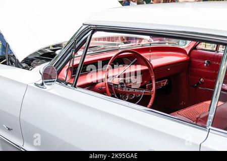 Babylon, New York, USA - 1. Juni 2019: Blick durch das Fahrerfenster auf das rote Interieur eines klassischen chevy Impala bei einer Automobilausstellung. Stockfoto