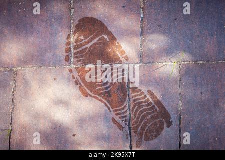 Nasse Schuhsohle auf dem Bürgersteig Stockfoto