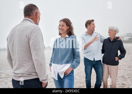 Familienbindung, Strand- und Außengespräche von Menschen, die gerne Zeit miteinander verbringen. Kommunikation einer Frau, eines Mannes und älterer Eltern auf Meersand Stockfoto