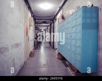 Ein langer Korridor im Inneren des Fushuijing-Gebäudes in Peking, China, mit blauen Schließfächern Stockfoto