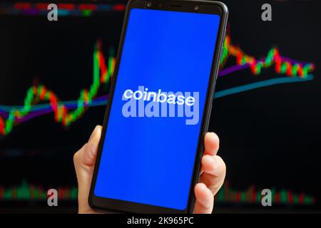 Ukraine, Odessa - Oktober, 9 2021: Coinbase mobile App läuft auf dem Smartphone-Bildschirm mit Trading Candlestick Chart im Hintergrund. Coinbase ist eine amerikanische Kryptowährungs- und Handelsplattform Stockfoto