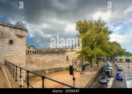 Blick von der Brücke aus auf alte Befestigungsmauern und Straße mit Autoverkehr in Avignon an regnerischen Tagen. Frankreich, Provence Stockfoto