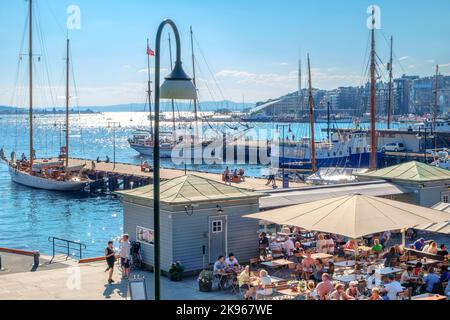 Hafen mit Yachten und Booten im Stadthafen. Blick auf Café im Freien im Sommer sonnigen Tag. Oslo, Norwegen Stockfoto