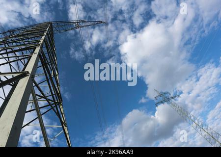 Strompylon zur Übertragung und Stromübertragung von Hochspannung durch natürliche Landschaften vor einem wolkigen Himmel Stockfoto