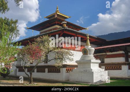 Landschaftlich reizvolle Aussicht auf das alte Kyichu lhakhang buddhistische Kloster im Frühjahr mit blühenden Bäumen, Paro, Westbhutan Stockfoto