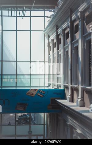 Eine Vertikale des Sonnenlichts, die durch die Glasscheibe des National Museum of Singapore scheint. Stockfoto