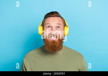 Foto von beeindruckt Kerl mit Ingwer Frisur verkleidet khaki lange Ärmel interessiert suchen leeren Raum isoliert auf teal Farbe Hintergrund Stockfoto