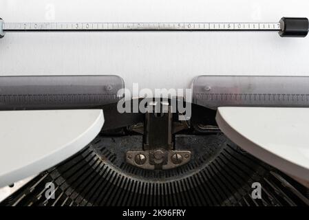Nahaufnahme von leerem weißem Papier mit Kopierplatz in alter mechanischer Schreibmaschine Stockfoto