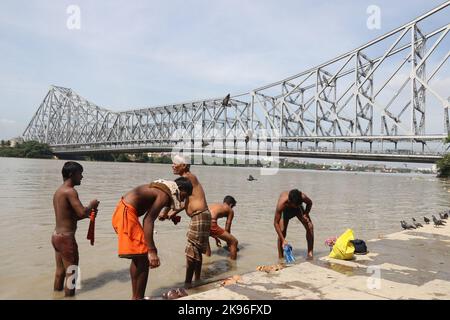 Kalkutta, Indien. 25. Oktober 2022. Während einer partiellen Sonnenfinsternis in Kalkutta baden die Menschen am Ufer des Hooghly River. (Foto von Dipa Chakraborty/Pacific Press) Quelle: Pacific Press Media Production Corp./Alamy Live News Stockfoto