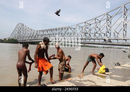 Kalkutta, Indien. 25. Oktober 2022. Während einer partiellen Sonnenfinsternis in Kalkutta baden die Menschen am Ufer des Hooghly River. (Foto von Dipa Chakraborty/Pacific Press) Quelle: Pacific Press Media Production Corp./Alamy Live News Stockfoto