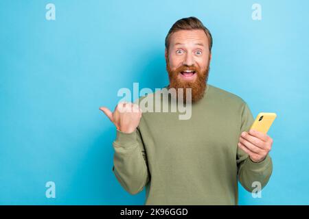 Foto von guten Laune Kerl mit roten Frisur gekleidet khaki Langarm-Telegramm instagram facebook twitter isoliert auf blauem Hintergrund Stockfoto