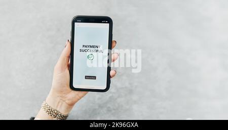 Frau, die mit dem Smartphone für Online-Shopping bezahlt. Bezahlen mit schnellem, sicherem Zahlungssystem. Frau zahlt Rechnungen mit Express-Zahlungstechnologie. Bezahlen Stockfoto