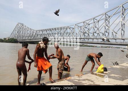 Kalkutta, Westbengalen, Indien. 25. Oktober 2022. Während einer partiellen Sonnenfinsternis in Kalkutta baden die Menschen am Ufer des Hooghly River. (Bild: © Dipa Chakraborty/Pacific Press via ZUMA Press Wire) Stockfoto