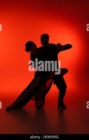 Silhouette eines Paares tanzender Tango auf rotem Hintergrund Stockfoto