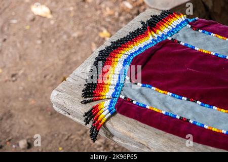 Ein karmesinroter Samtschal wurde mit farbenfrohen indianischen Perlenarbeiten ausgestattet. Stockfoto