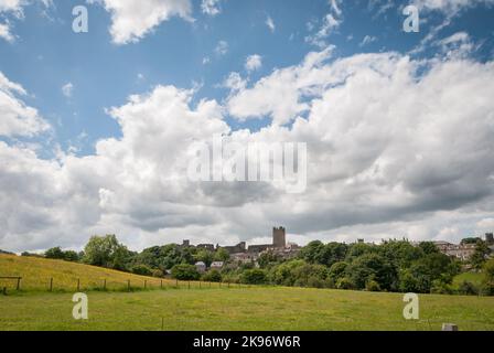 Blick über Felder auf Richmond Castle und Richmond Town an einem Sommertag mit weißen, flauschigen Wolken Stockfoto