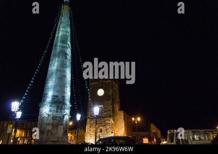 Richmond, North Yorkshire, Großbritannien - 23. November 2009: Der Obelisk im Richmond Market Place, North Yorkshire mit dem Green Howards Regimental Museum in t Stockfoto