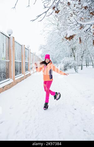 Wintertraining, Training bei kaltem Wetter. Winter Fitness Trening kangoo Sprünge. Sportliche Frau in Sportswear und kangoo-Sprungschuhe springen im Winter Stockfoto