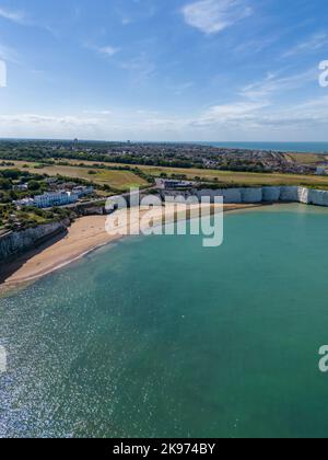 Die wunderschönen weißen Kreidefelsen und Gebäude am blauen Himmel in Kingsgate Bay Beach Stockfoto