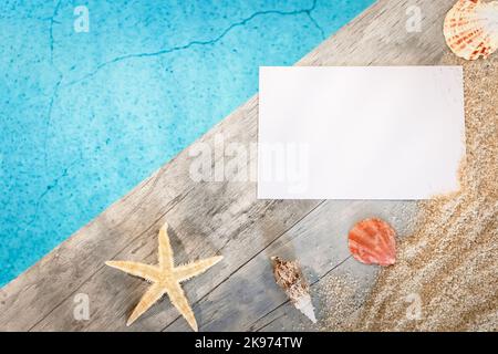 Muscheln von oben auf einem Holzpflaster über einem Pool mit Seesternen gesehen. Atmosphärenurlaub im Sommer. Stockfoto