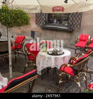 WARSCHAU, POLEN - 20. JUNI 2016: Farbenfrohe Tische und Stühle in einem hübschen Straßencafé in der Altstadt Stockfoto