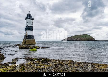 Der historische Leuchtturm Trwyn Du Penmon am Ufer in Penmon, Wales Stockfoto