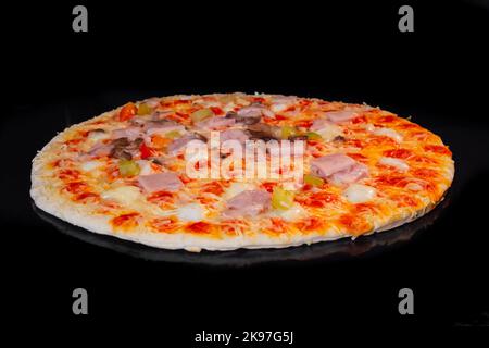 Hausgemachte Pizzabacken auf Blech im Elektroofen, schwarzer Hintergrund Stockfoto