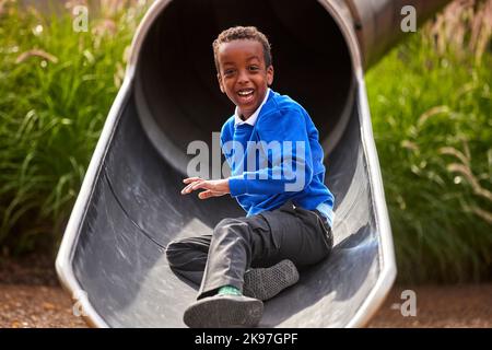 Mayfield Park Manchester, Kind spielt auf der Rutsche Stockfoto