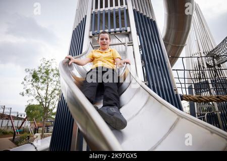 Mayfield Park Manchester, ein Kind, das auf der Rutsche spielt Stockfoto