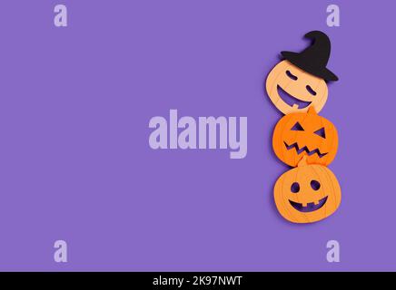 Halloween-Banner mit drei Papierkürbissen auf violettem Hintergrund. Stockfoto