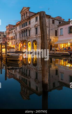 20. August 2022, chioggia, Italien: Touristen genießen die Sommerabende auf den Terrassen der Restaurants entlang des Kanals von Chioggia in Venetien. Chioggia, eine Stadt in der venezianischen Lagune, die viele Touristen beherbergt, die Venedig besuchen, wurde nicht in den venezianischen Stadtkern aufgenommen. Touristen, die dort bleiben, müssen die Steuer jedes Mal zahlen, wenn sie Venedig ab dem 16. Januar 2023 besuchen. (Bild: © Laurent Coust/SOPA Images via ZUMA Press Wire) Stockfoto