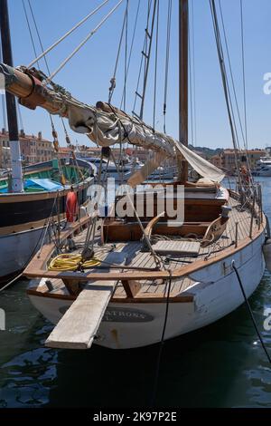 Saint-Tropez, Frankreich - 8. August 2022 - Luxusyachten, Boote und Segelboote säumen den Hafen gegenüber von Geschäften und Cafés in der Altstadt Stockfoto