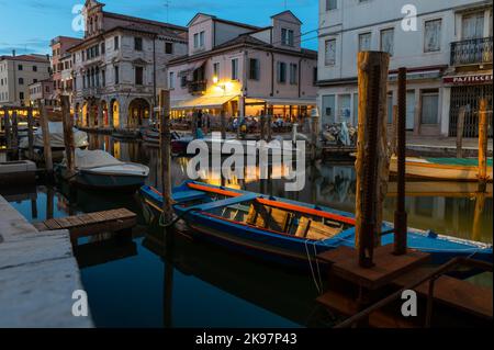 20. August 2022, chioggia, Italien: Touristen genießen die Sommerabende auf den Terrassen der Restaurants entlang des Kanals von Chioggia in Venetien. Chioggia, eine Stadt in der venezianischen Lagune, die viele Touristen beherbergt, die Venedig besuchen, wurde nicht in den venezianischen Stadtkern aufgenommen. Touristen, die dort bleiben, müssen die Steuer jedes Mal zahlen, wenn sie Venedig ab dem 16. Januar 2023 besuchen. (Bild: © Laurent Coust/SOPA Images via ZUMA Press Wire) Stockfoto