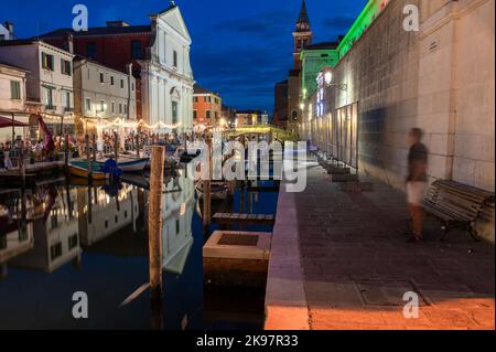 20. August 2022, chioggia, Italien: Touristen genießen die Sommerabende auf den Terrassen der Restaurants entlang des Kanals von Chioggia in Venetien. Chioggia, eine Stadt in der venezianischen Lagune, die viele Touristen beherbergt, die Venedig besuchen, wurde nicht in den venezianischen Stadtkern aufgenommen. Touristen, die dort bleiben, müssen die Steuer jedes Mal zahlen, wenn sie Venedig ab dem 16. Januar 2023 besuchen. (Bild: © Laurent Coust/SOPA Images via ZUMA Press Wire) Stockfoto