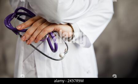 Arzt mit Stethoskop. Auf dem Hintergrund des verschwommenen Krankenhauskorridors. Stockfoto