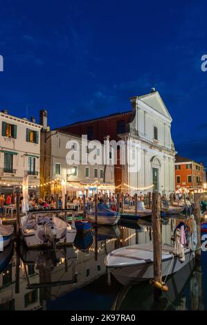 20. August 2022, chioggia, Italien: Touristen genießen die Sommerabende auf den Terrassen der Restaurants entlang des Kanals von Chioggia in Venetien. Chioggia, eine Stadt in der venezianischen Lagune, die viele Touristen beherbergt, die Venedig besuchen, wurde nicht in den venezianischen Stadtkern aufgenommen. Touristen, die dort bleiben, müssen die Steuer jedes Mal zahlen, wenn sie Venedig ab dem 16. Januar 2023 besuchen. (Bild: © Laurent Coust/SOPA Images via ZUMA Press Wire) Stockfoto