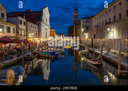 20. August 2022, chioggia, Italien: Touristen genießen die Sommerabende auf den Terrassen der Restaurants entlang des Kanals von Chioggia in Venetien. Chioggia, eine Stadt in der venezianischen Lagune, die viele Touristen beherbergt, die Venedig besuchen, wurde nicht in den venezianischen Stadtkern aufgenommen. Touristen, die dort bleiben, müssen die Steuer jedes Mal zahlen, wenn sie Venedig ab dem 16. Januar 2023 besuchen. (Bild: © Laurent Coust/SOPA Images via ZUMA Press Wire) Stockfoto