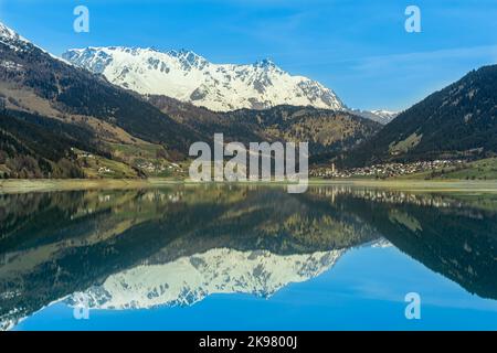 Panoramablick auf den See in den Bergen. Mit dem Dorf Reschen in Südtirol, Südtirol, Trentino-Südtirol, Italien, Europa Stockfoto