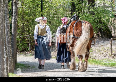 Elsass, Frankreich - 20.04.2022-zwei Mädchen in traditioneller Kleidung mit einem Pferd im Ecomuseum Elsass in der Stadt Mulhouse, Elsass, Frankreich Stockfoto