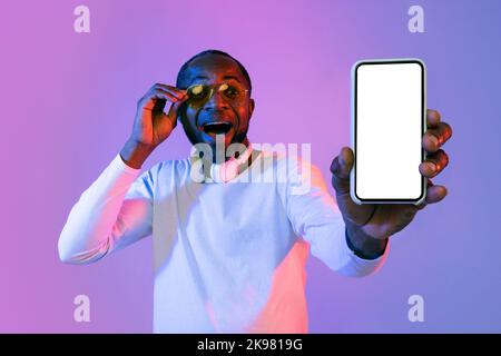 Erstaunt afroamerikanischen Mann hält Smartphone, mockup Stockfoto