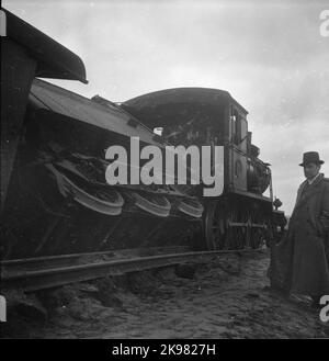 Tränenverfolgung in Bredaryd. Rechts im Bild steht die Dampflokomotive hnj Lokomotive 28, gefolgt vom entgleisten Tender und ganz links ist der Gepäckwagen HNJ F3 761 zu sehen. Der Zug war auf dem Weg nach Halmstad. Sie gehörte der Halmstad-Nässjö Eisenbahn, HNJ, und wurde von der Dampflokomotive HNJ 28 gezeichnet und bestand aus vier Waggons. Ein Gepäckwagen, HNJ F3 761, ein Postauto hnj 19 und zwei Pkw einschließlich HNJ 1011. Stockfoto