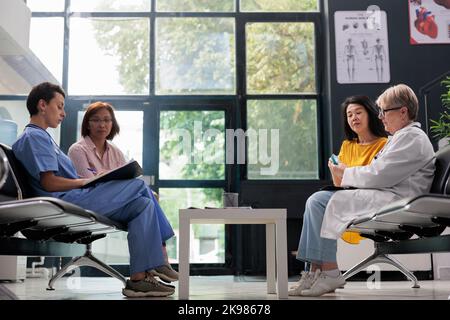 Asiatischer Patient, der die Kontrolle von Diabetes-Rutin mit dem Glucometer-Instrument durchführt, Arzt, der den Glukosezuckerspiegel beim Insulintest misst. Medic überprüft Blutprobe für diabetische alte Frau im Krankenhausbereich. Stockfoto