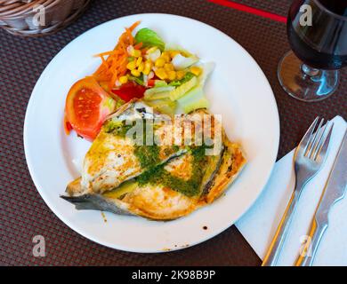 Gegrillte Goldbrasse mit Pesto, serviert mit Gemüsesalat Stockfoto